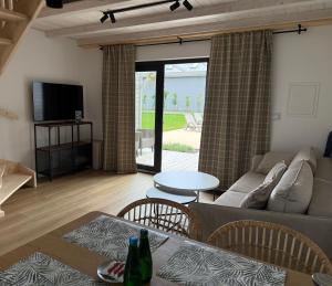 a living room with a couch and a table at Mamma Mia Park in Łukęcin