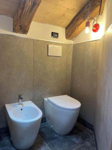 un bagno con un water bianco e un lavandino di Mansarda Belvedere ad Auronzo di Cadore Altre 12 foto