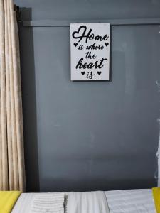 a bedroom with a sign that reads home is where the heart is at LV Homes in Ongata Rongai  +1 photo