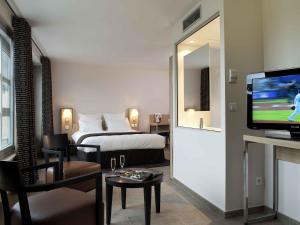 a hotel room with a bed and a flat screen tv at Hôtel Mercure Thionville Centre Porte du Luxembourg in Thionville