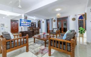 a living room with two benches and a table at Villa Cashew Diani in Diani Beach +101 photos
