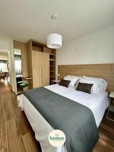 a bedroom with a large bed with a large white bedspread at HOMEY Departamentos in Mar del Plata