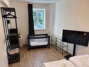 sala de estar con cama y TV de pantalla plana en Cozy Castle Königstein - Moderne 69 qm Unterkunft, en Königstein