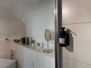 Un baño con un espejo y una botella de vino en un estante. en Cozy Castle Königstein - Moderne 69 qm Unterkunft, en Königstein 22 fotos más