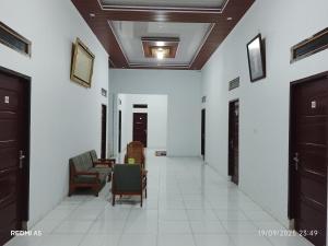a hallway with chairs and a table in a building at Wisma sane in Teratakairhitam