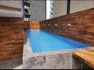 a swimming pool in a building with a brick wall at Lindo Apart - Churrasquera y Patio Privado in Santa Cruz de la Sierra