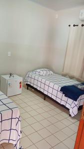 two beds in a room with a tiled floor at Hotel Vale do Sol in Valparaíso +8 photos