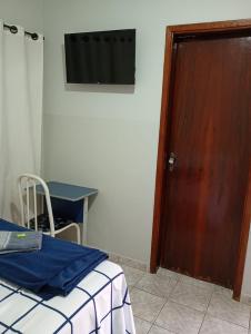 a room with a bed and a wooden door at Hotel Vale do Sol in Valparaíso