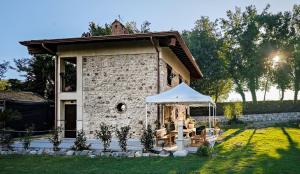 a building with a table and a white umbrella at Casale Tre Moschetti in Prossedi