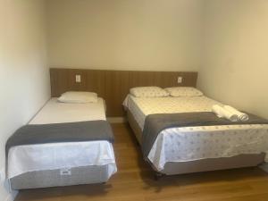two beds in a small room with at Hotel Ledo in Bom Jesus da Lapa