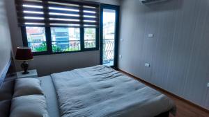 Un dormitorio con una cama y una ventana grande en Midtown home, en Hanói