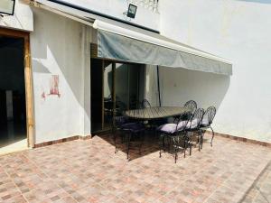 a patio with a table and chairs on a patio at Belle maison avec piscine à 7 min de la plage en voiture in Dar Bouazza