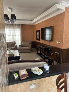 Una sala de estar con un sofá y un televisor. en Luxurious 5 bedroom Furnished Villa superb locationفيلا فخمه, en Amán
