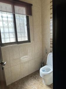Un baño con inodoro y ventana. en Luxurious 5 bedroom Furnished Villa superb locationفيلا فخمه, en Amán