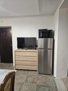 a kitchen with a stainless steel refrigerator and a tv at Izi Apartman in Husain