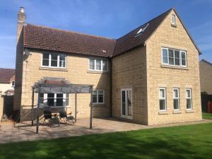 a large brick house with a canopy in front of it at Immense 6 bed with massive garden right on A1 in Holme