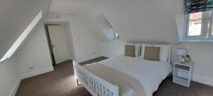 a white bedroom with a bed and a window at Immense 6 bed with massive garden right on A1 in Holme