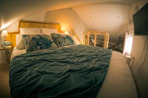 ein Schlafzimmer mit einem großen Bett mit einer grünen Bettdecke in der Unterkunft Adorelys séjour bien être - spa et massage in Saint-Cassien
