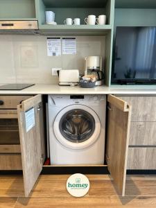 a washing machine in a kitchen with a tv at HOMEY Departamentos in Mar del Plata +37 photos