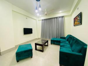 a living room with a blue couch and a tv at CityLights Bashundhara Kensington Grand Collection in Dhaka