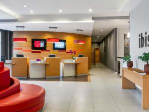 an office with a lobby with a red chair and desks at Ibis Bursa in Bursa