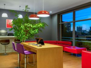 a office with a desk and red chairs and a table with a laptop at Ibis Bursa in Bursa