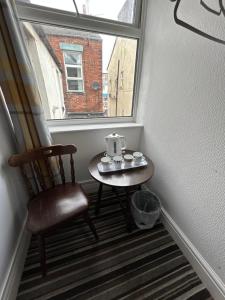 a small table with a tea kettle on it next to a window at Cadeby Lodge in Blackpool
