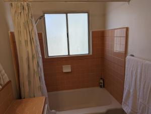 ein Badezimmer mit Badewanne und Fenster in der Unterkunft Large 3 Bedroom near everything in San Diego in San Diego