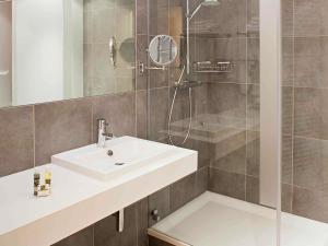 een badkamer met een wastafel en een douche bij Hôtel Mercure Vittel in Vittel +33 foto's