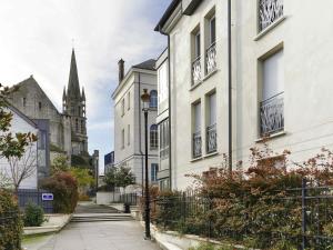 a street with white buildings and a church at ibis Etampes in Étampes