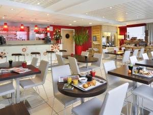 a restaurant with tables and chairs with food on them at ibis Etampes in Étampes