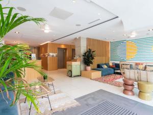 a living room with a blue couch and some plants at Mercure Président Biarritz Plage in Biarritz