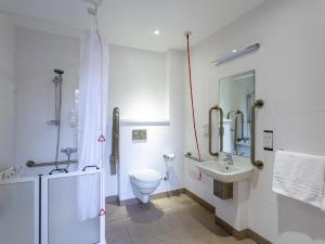 a white bathroom with a toilet and a sink at ibis Belfast Queens Quarter in Belfast +54 photos
