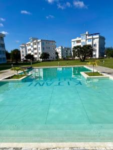 an empty swimming pool with buildings in the background at Nautical Nest Apartments in Malindi