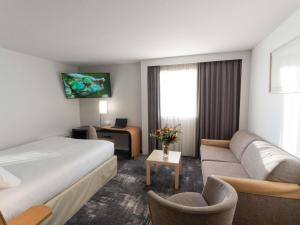 une chambre d'hôtel avec un lit et un canapé dans l'établissement Novotel Nantes Centre Bord de Loire, à Nantes 97 autres photos