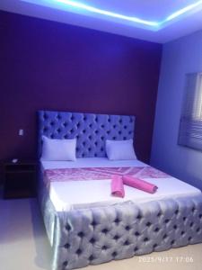 a bedroom with a large bed with a pink ribbon on it at Cutting Edge Guest House in Daranka