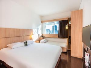 een hotelkamer met twee bedden en een raam bij ibis Bogota Museo in Bogota +29 foto's