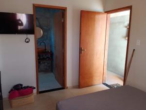 ラゴイーニャにあるRecanto dos Borgesのガラスの引き戸と鏡のある寝室