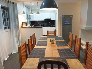 a dining room with a table and a kitchen at Hôtel Les 12 Collines, Ivato Aéroport in Abohijanahary