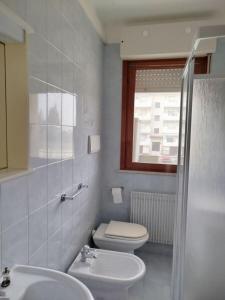 ein weißes Badezimmer mit Toilette und Waschbecken in der Unterkunft Cozy studio with pool in Caorle in Caorle