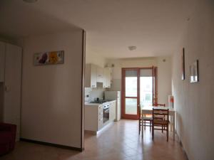 eine Küche und ein Esszimmer mit Tisch und Stühlen in der Unterkunft Cozy studio with pool in Caorle in Caorle
