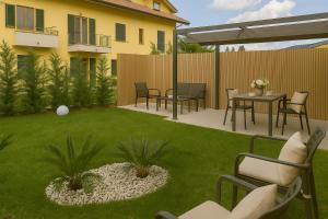 a patio with chairs and a table in a yard at Casa Nova Garden in Arsago Seprio