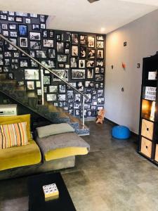 a room with a couch and a staircase with pictures on the wall at Irishhome stay in Hosūr