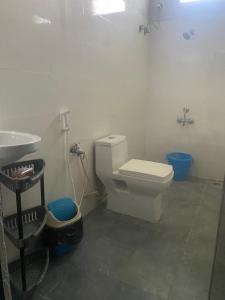 a bathroom with a white toilet and a sink at Irishhome stay in Hosūr +26 photos