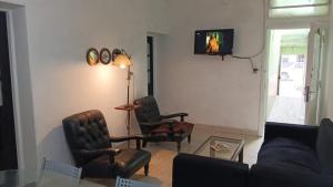 sala de estar con 2 sillas y TV en la pared en Juanita, en Buenos Aires