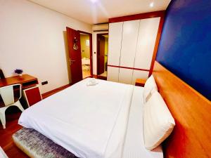 a bedroom with a white bed and a desk at vortex KLCC YOUR HOME in Kuala Lumpur
