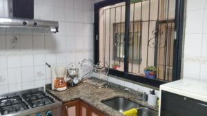 Una cocina con fregadero, estufa y ventana. en Juanita, en Buenos Aires 12 fotos más