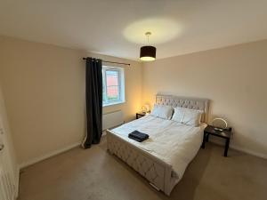 un dormitorio con una cama y una ventana en Aylesbury, en Buckinghamshire