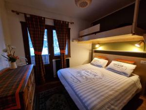 una camera da letto con un letto con due cuscini sopra di Spazioso appartamento vicino al centro a Bormio Altre 20 foto