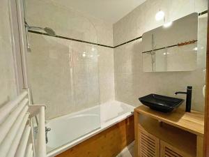 a bathroom with a bath tub and a sink at Appartement aux Menuires avec cuisine équipée, balcon et animaux admis - FR-1-452-15 in Les Menuires +15 photos